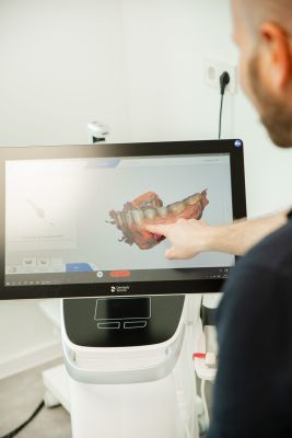 Ein Zahnarzt wertet einen digitalen 3D-Zahnabdruck am Monitor aus