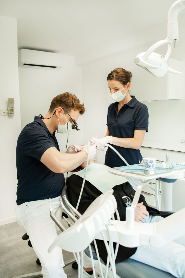 Zahnarzt und Assistenz bei der Behandlung eines Patienten im modernen Behandlungszimmer